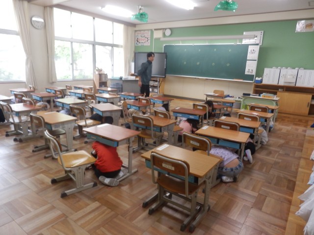 机の下にもぐって、頭を守ります。